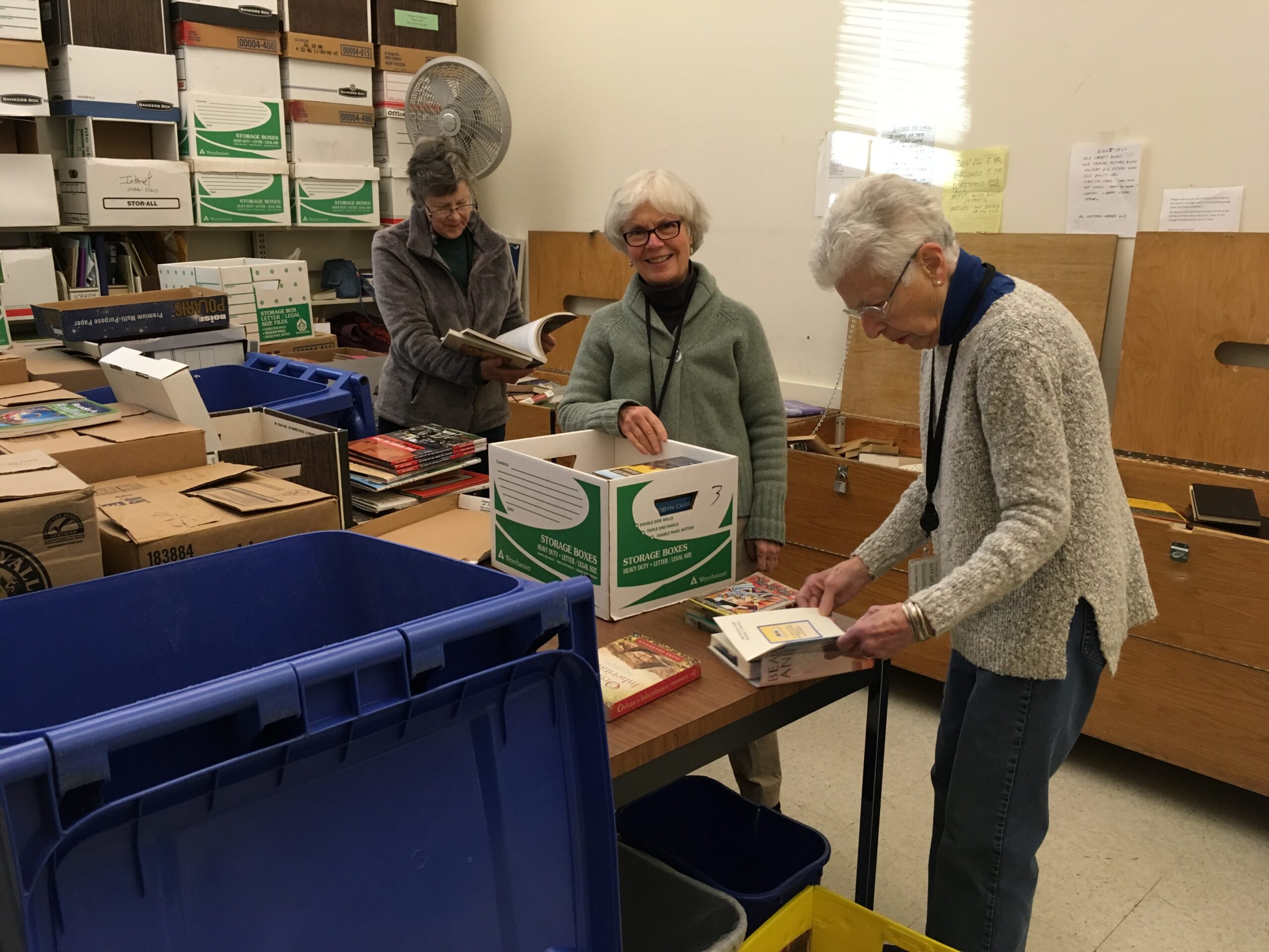 Three volunteers sorting books