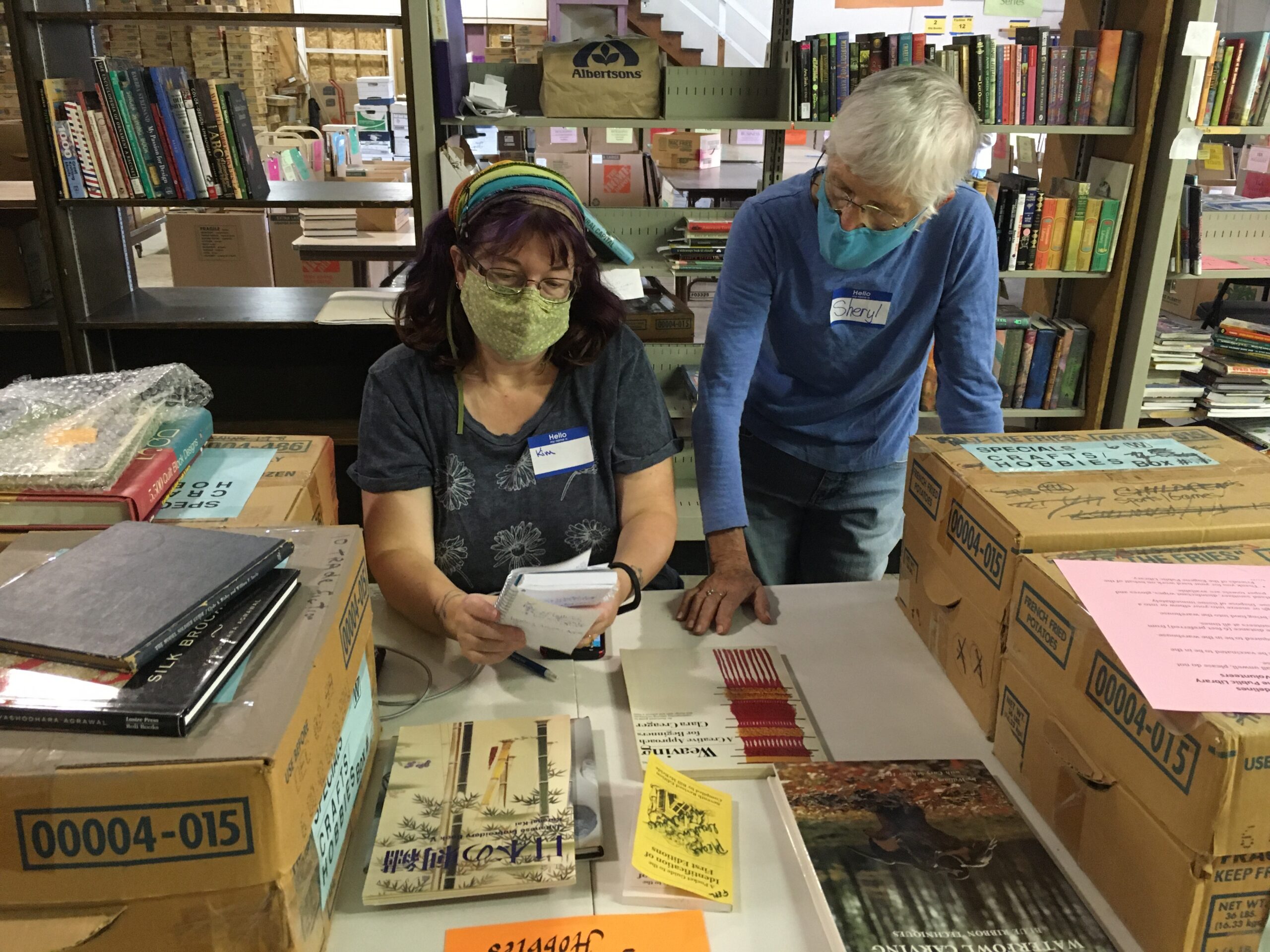 Two volunteers pricing books